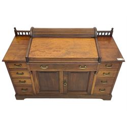 Victorian walnut clerk's desk, raised central section with tambour roll over hinged top, the interior fitted with leather inset writing surfaces, small drawers, document divisions and pen and ink stand, central drawer over double panelled cupboard, flanked by two banks of four graduating drawers, on bracket feet 