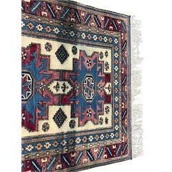 Turkish camel ground rug, three medallions surrounded by geometric motifs, the border decorated with stylised leaf motifs