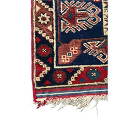 Turkish crimson ground rug, the field decorated with three geometric medallions within a band of star motifs, the main border decorated with stylised plant motifs 