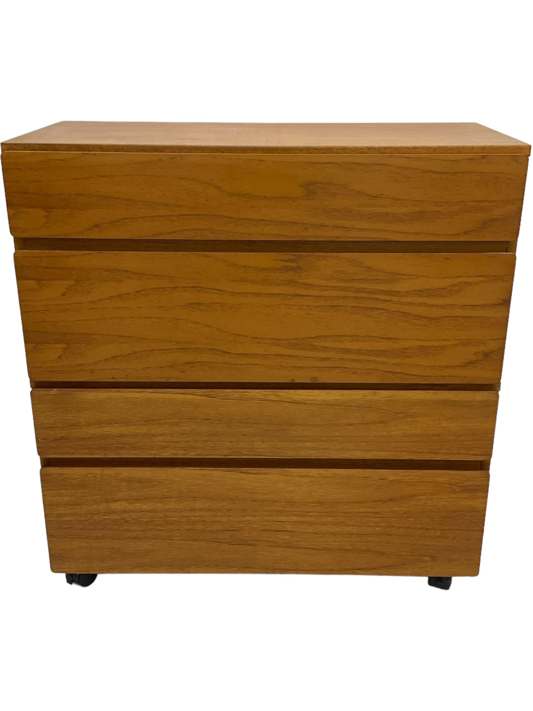 Mid-20th century teak four-drawer chest, featuring a minimalist design with two shallow and two deep flush drawer fronts, each with recessed handles along the top edge, the drawers open to reveal white laminate interiors, supported by castors