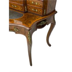 19th century French figured walnut Bonheur de Jour or writing desk, the upper section with brass gallery over mirror glazed cupboard and a combination of drawers, shaped and moulded top with leather inset and satinwood band, fitted with single drawer, on cabriole supports, inlaid throughout with scrolling foliate decoration in boxwood, ornate cast brass mounts 