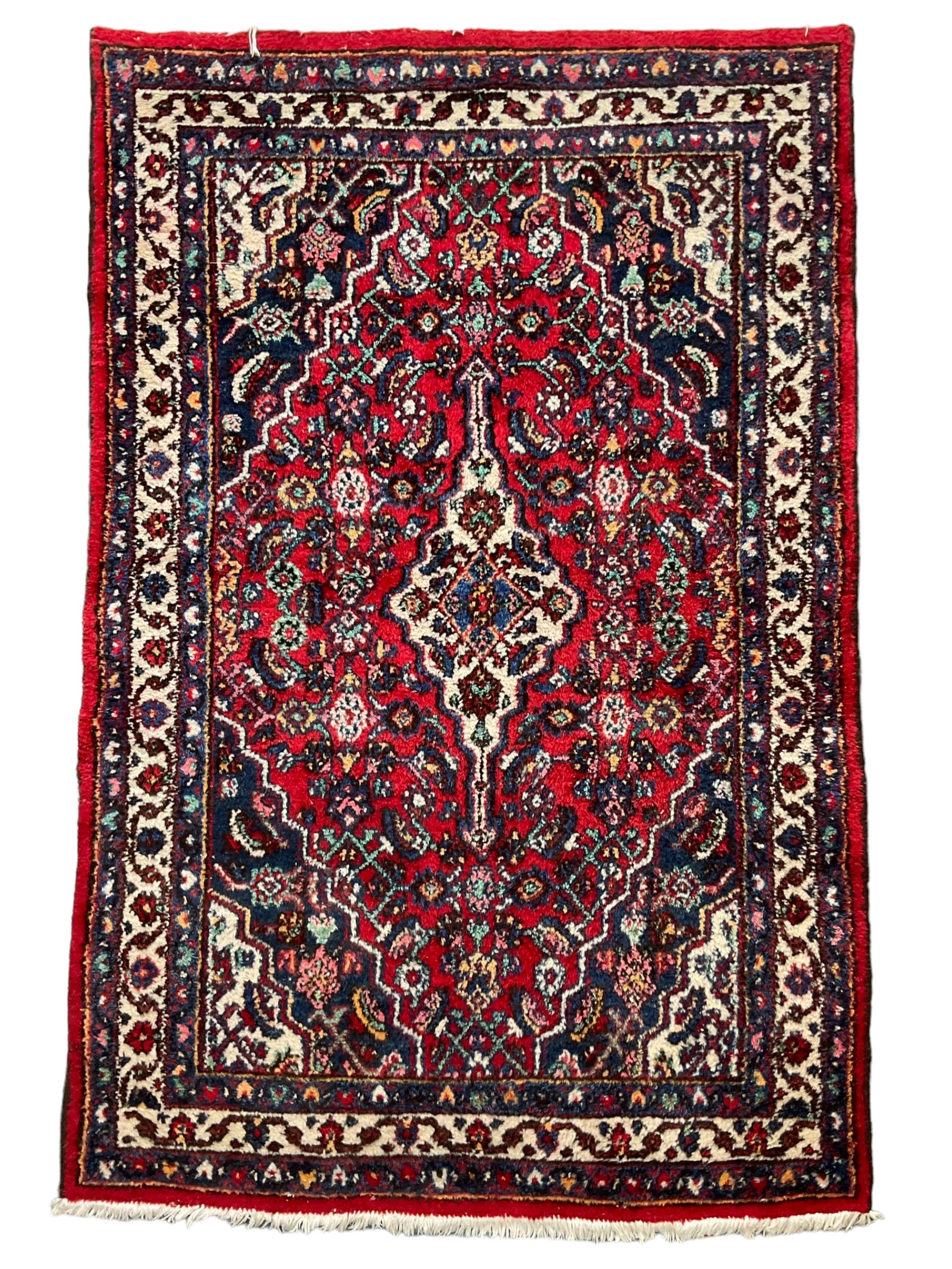 Persian Herati crimson ground rug, central ivory pole medallion surrounded by Herati motifs, with contrasting indigo spandrels, multi-band border with interlaced flowerheads