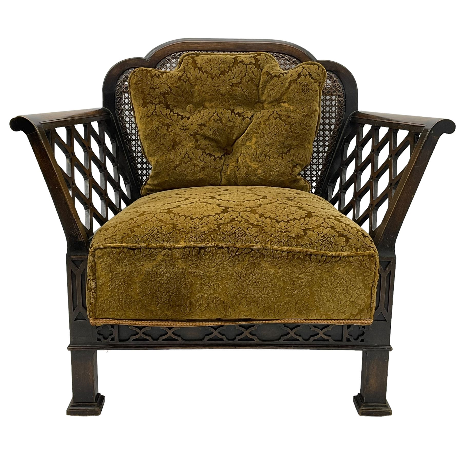 Early 20th century three-piece bergère suite - three seat sofa (W177cm, H82cm, D75cm); pair of matching armchairs (W84cm); single caned back with 'cock-pen' panelled arms, upholstered in foliate pattern fabric, blind fretwork lower frieze over square feet 