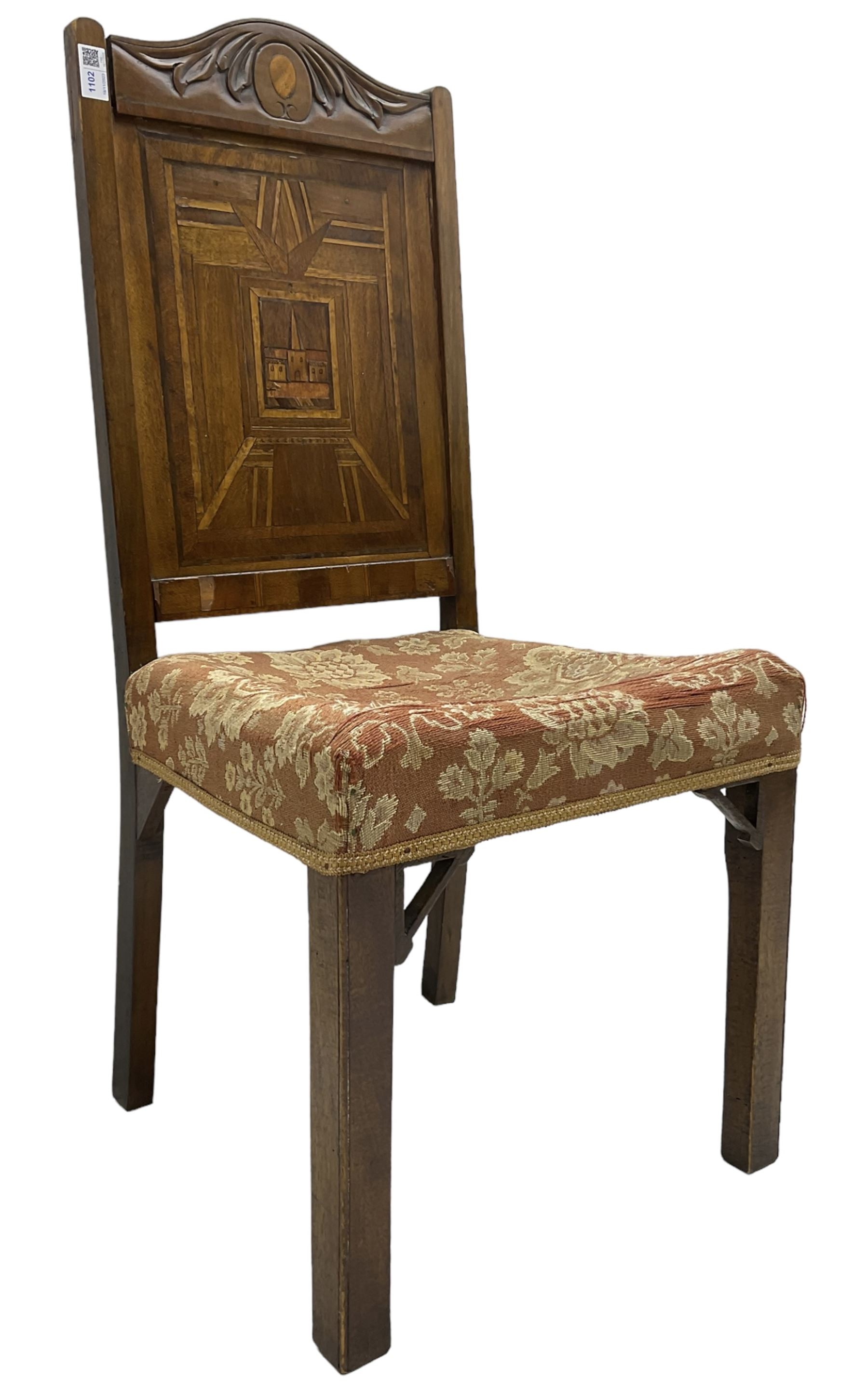 19th century walnut side chair, foliage carved cresting rail over geometric inlaid back with central panel depicting buildings, upholstered seat, on moulded and chamfered square supports