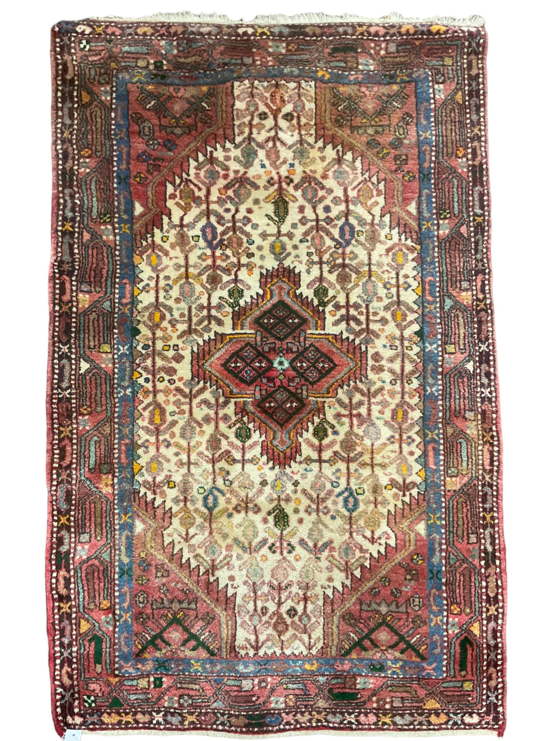 Small Persian rug, ivory and pale red ground, decorated with central medallion within a field of trailing Boteh motifs, geometric design guarded border