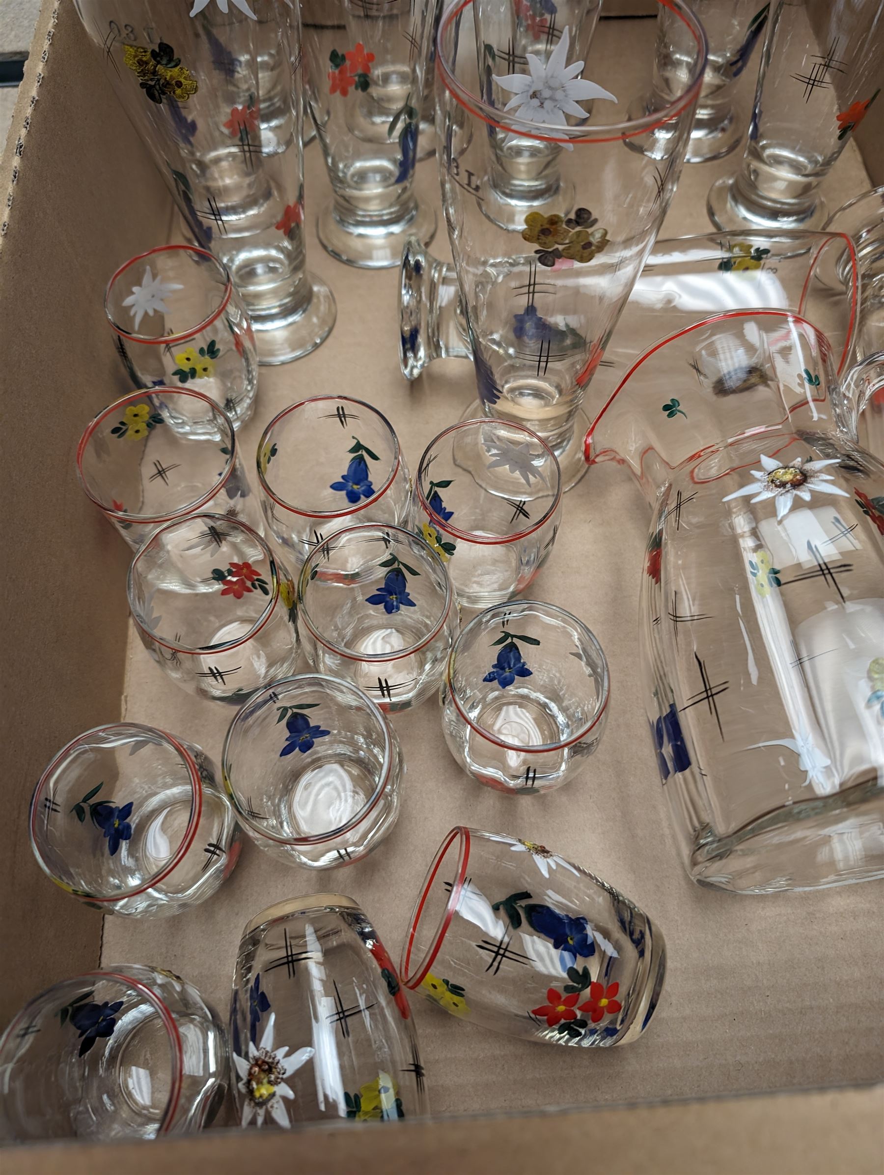 Glass lemonade set, comprising a collection of glasses and a jug, all painted in red and yellow flowers