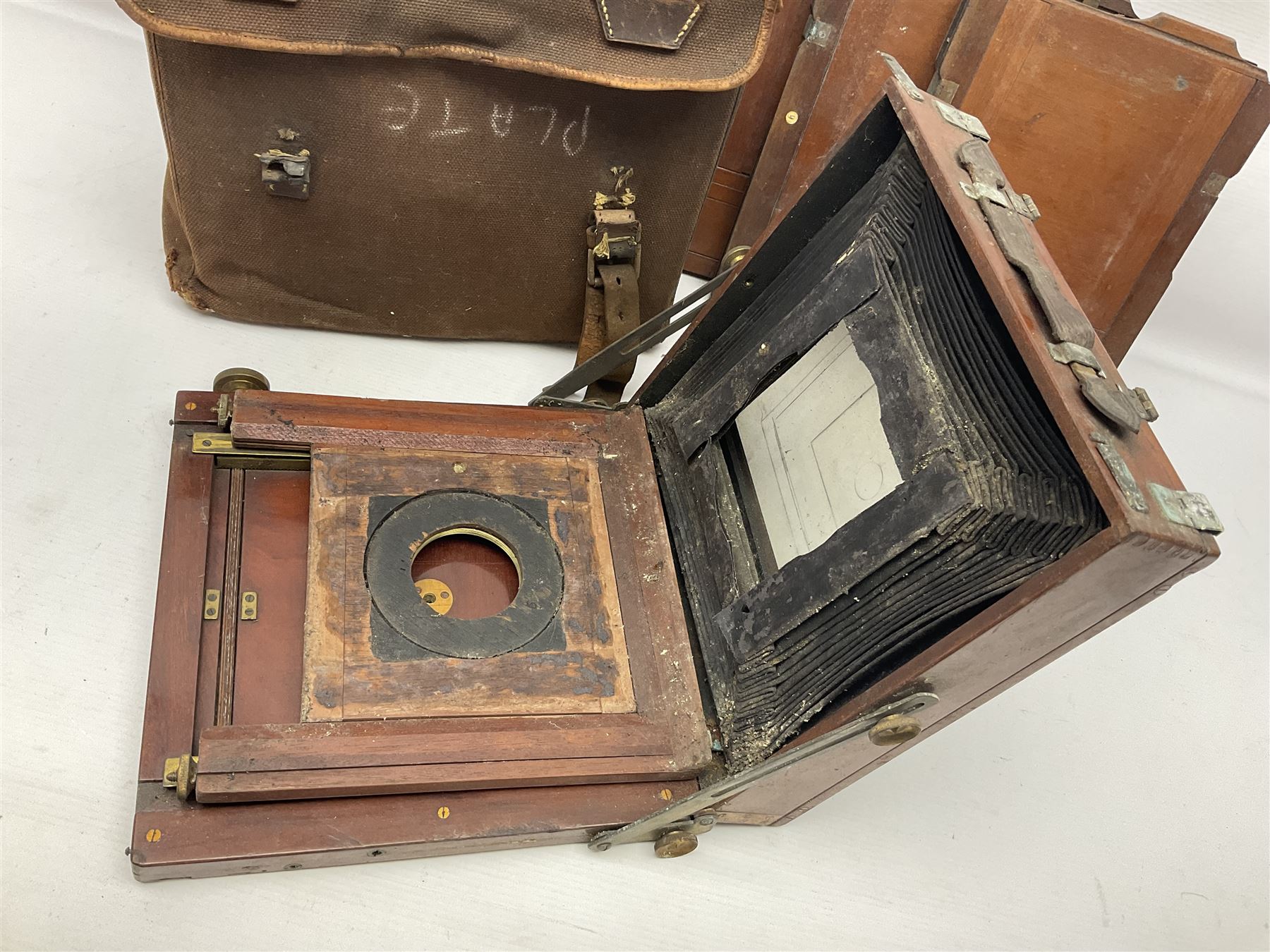 Folding plate camera in mahogany and lacquered brass, with additional plates and case