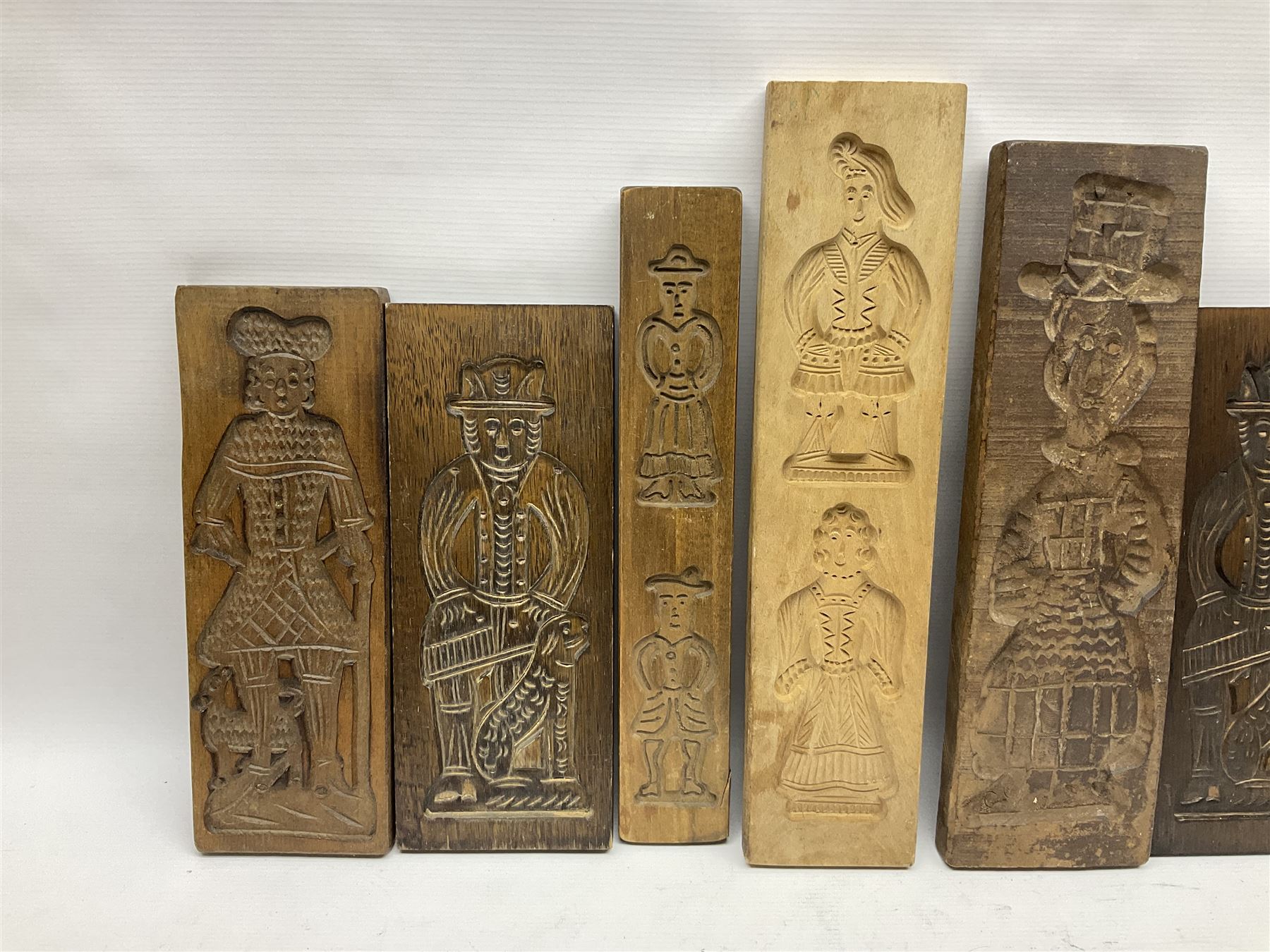 Collection of 20th century beech and other hardwood Dutch folk art Speculaasplank or biscuit moulds, most examples typically carved with figures in traditional dress, tallest H52cm