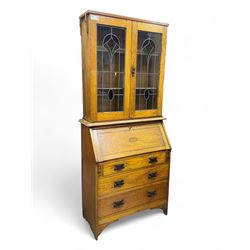 Early 20th century Arts and Crafts oak bureau bookcase, twin leaded and glazed stained gla...