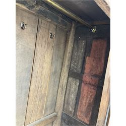 17th century and later oak hall cupboard, panelled front and sides with moulded frame, enclosed by single door with wrought metal hinges and handle, the interior fitted with hooks, on stile supports 