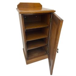 Edwardian oak bedside cabinet, raised back over moulded top, enclosed by panelled door, the interior fitted with shelves, on chamfered plinth base 