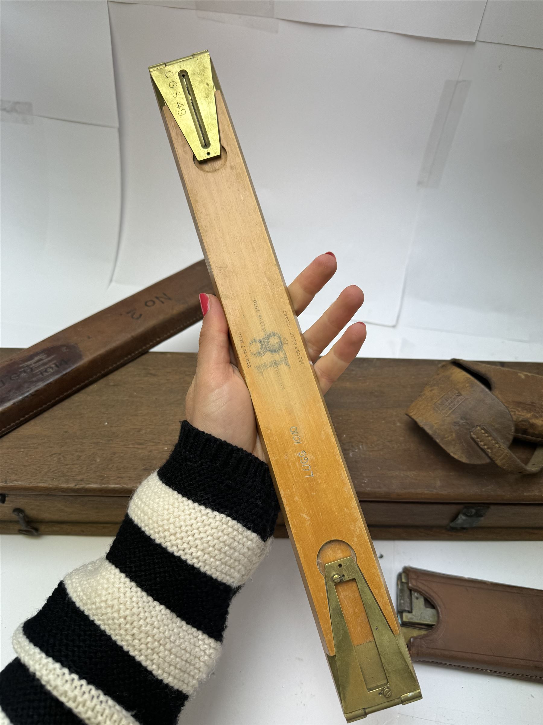 Early 20th century drawing instruments, to include a boxed set of large compasses, possibly for map drawing, marked 5, 6 and 7 miles, in fitted wooden case, together with two rules marked W. Harling and a parallel rule stamped R. E & Co MK II, all with broad arrow mark, contained within leather cases