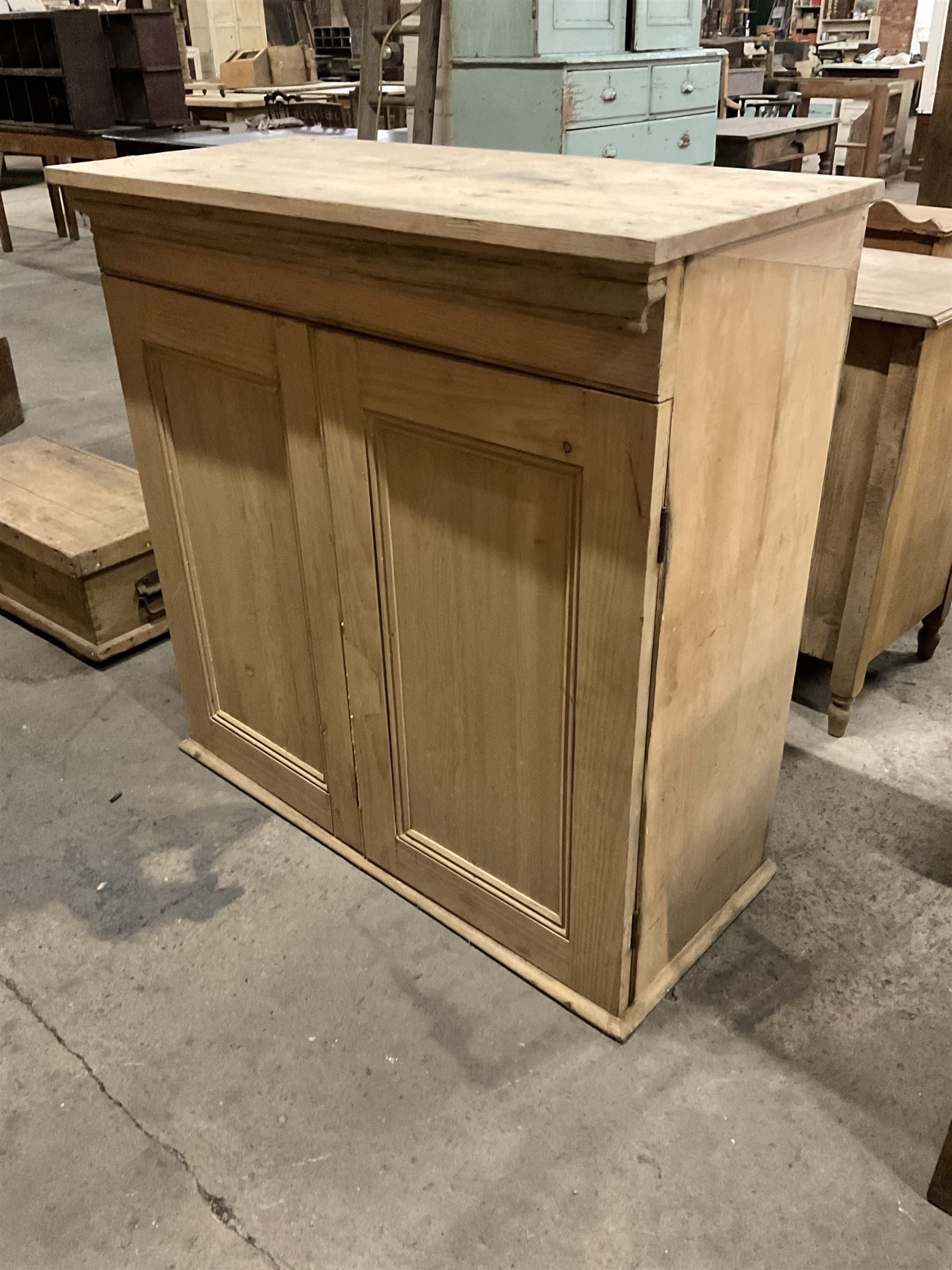 Stripped pine cupboard or bookcase, projecting cornice over two panelled doors, enclosing two shelves - THIS LOT IS TO BE COLLECTED BY APPOINTMENT FROM THE OLD BUFFER DEPOT, MELBOURNE PLACE, SOWERBY, THIRSK, YO7 1QY