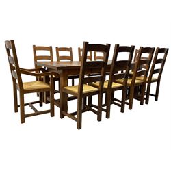 Antix Furniture - oak extending refectory dining table, rectangular plank top with two additional leaves and two drawers to the longer side, on square supports connected by H-stretcher; set of ten (8+2) ladder back dining chairs with rush seats