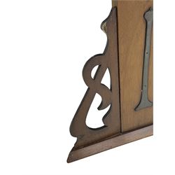 Arts & Crafts period walnut overmantel mirror, shaped pediment over shelf, rectangular bevelled mirror plate within applied mouldings, shaped and pierced corner brackets, decorated with shaped copper mounts 