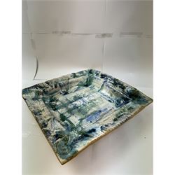 Large studio pottery dish, of square form, with applied and embossed foliate detail on a mottled green/blue ground, W42cm