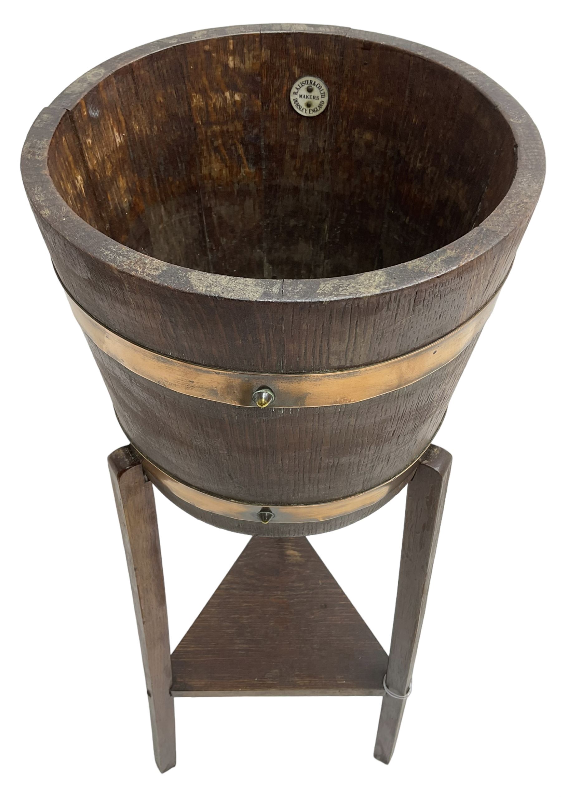 RA Lister & Co, Dursley - early 20th century oak jardinière plant stand, coopered barrel on three splayed supports united by undertier 