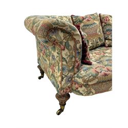 Mid-19th century walnut framed two-seat sofa, rolled arms over sprung seat, single drop-end action, raised on turned and fluted feet with brass cups and castors, upholstered by E & S Gott in traditional floral pattern fabric decorated with urns