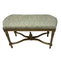 French Louis XIV design giltwood framed bench or window seat, sprung seat upholstered in pale blue foliate damask fabric with studwork border, raised on gesso moulded and carved tapering supports united by curved X-stretcher, with central acanthus carved finial