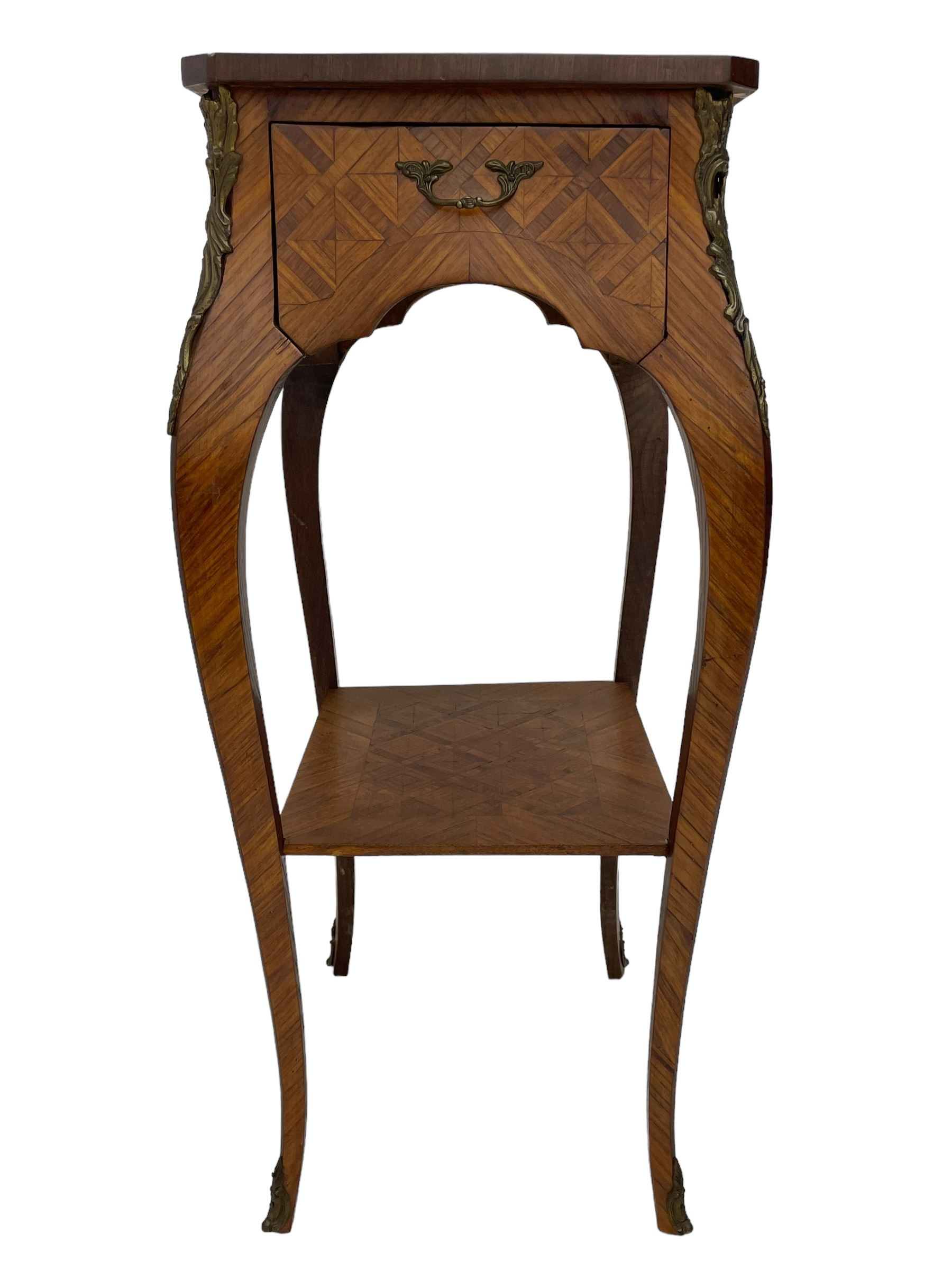 Late 20th century French design Kingwood lamp table, shaped form with geometric parquetry inlaid top within band and raised lip, fitted with single drawer and slide, on cabriole supports united by undertier, decorated with ornate cast gilt metal mounts and terminal caps 