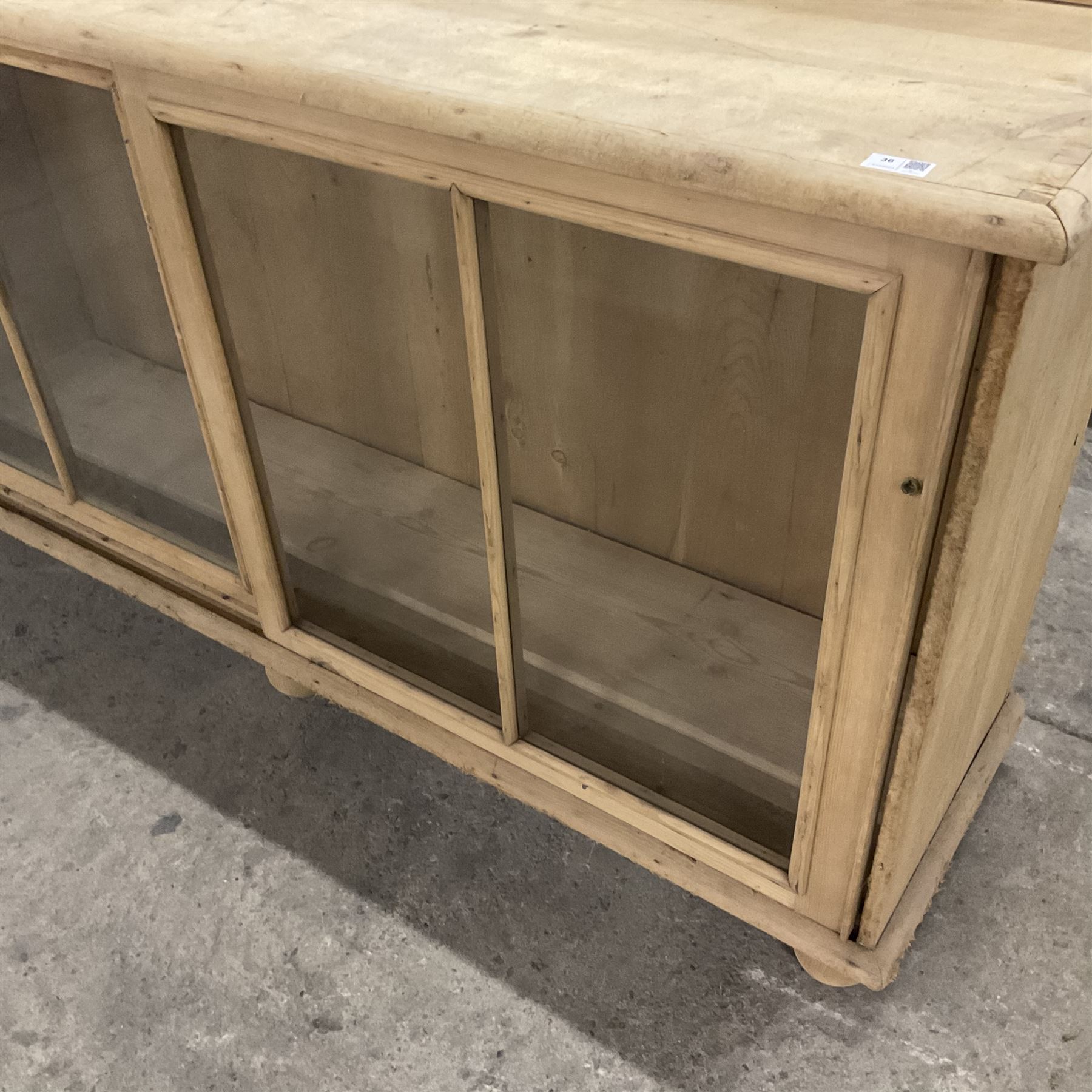 19th century pine cabinet, raised shaped back over rectangular top, enclosed by two sliding glazed doors, on turned feet - THIS LOT IS TO BE COLLECTED BY APPOINTMENT FROM THE OLD BUFFER DEPOT, MELBOURNE PLACE, SOWERBY, THIRSK, YO7 1QY