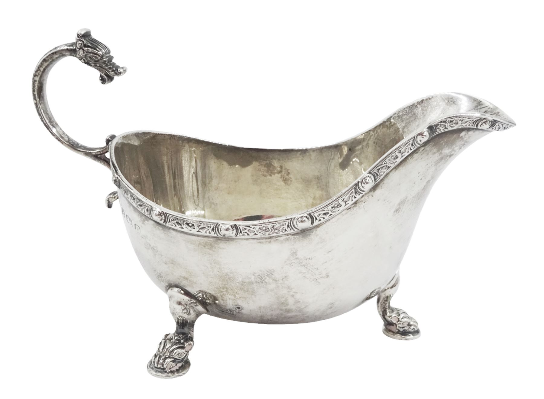 Early 20th century silver sauce boat, of typical form with flying scroll handle, the handle and feet modelled as Viking style dragon heads, hallmarked Adie Brothers Ltd, Birmingham, date mark indistinct, possibly 1940, including handle H9cm