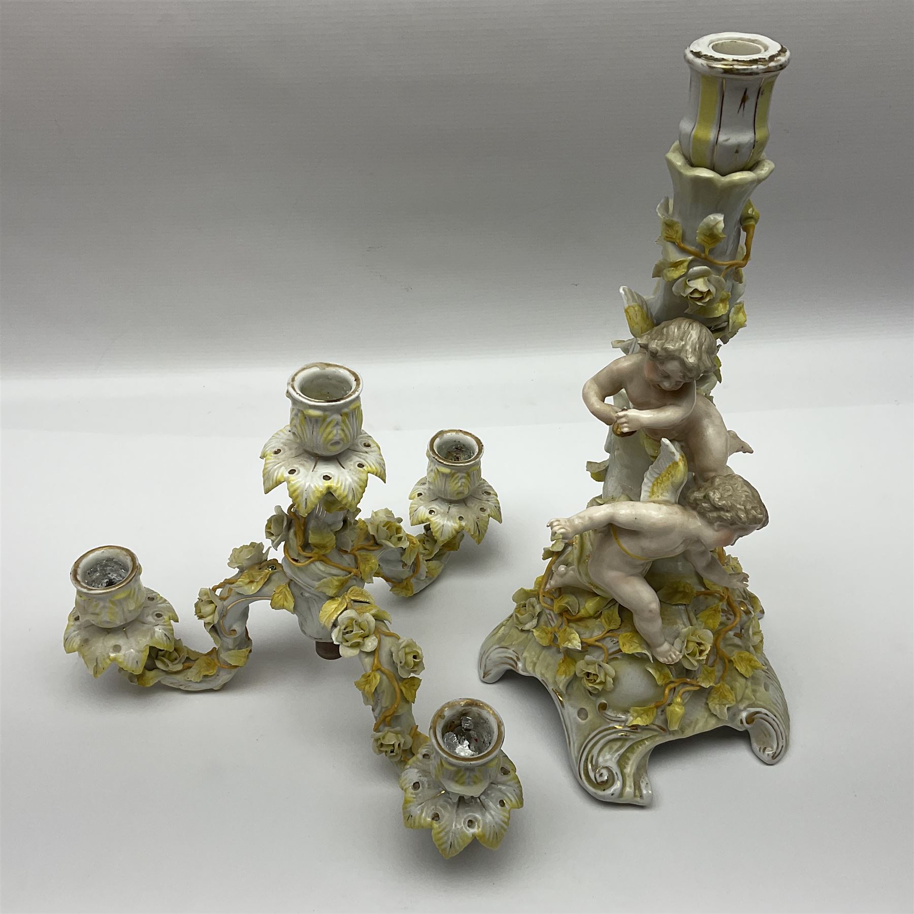 Dresden style candelabra, the central stem bordered by three branches, decorated with cherubs and yellow roses, H48cm