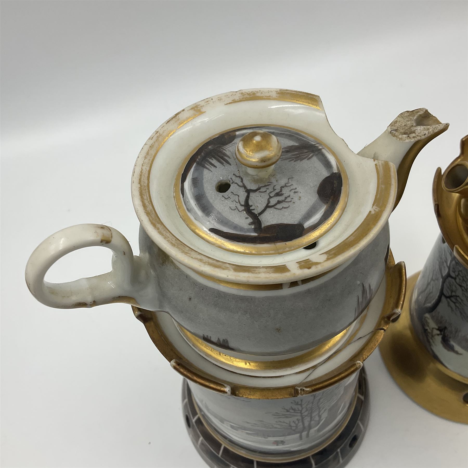 Two 19th century continental teapots and warmers, each teapot upon a cylindrical warming base in the form of a castle, hand printed with winter landscapes, largest H22cm 