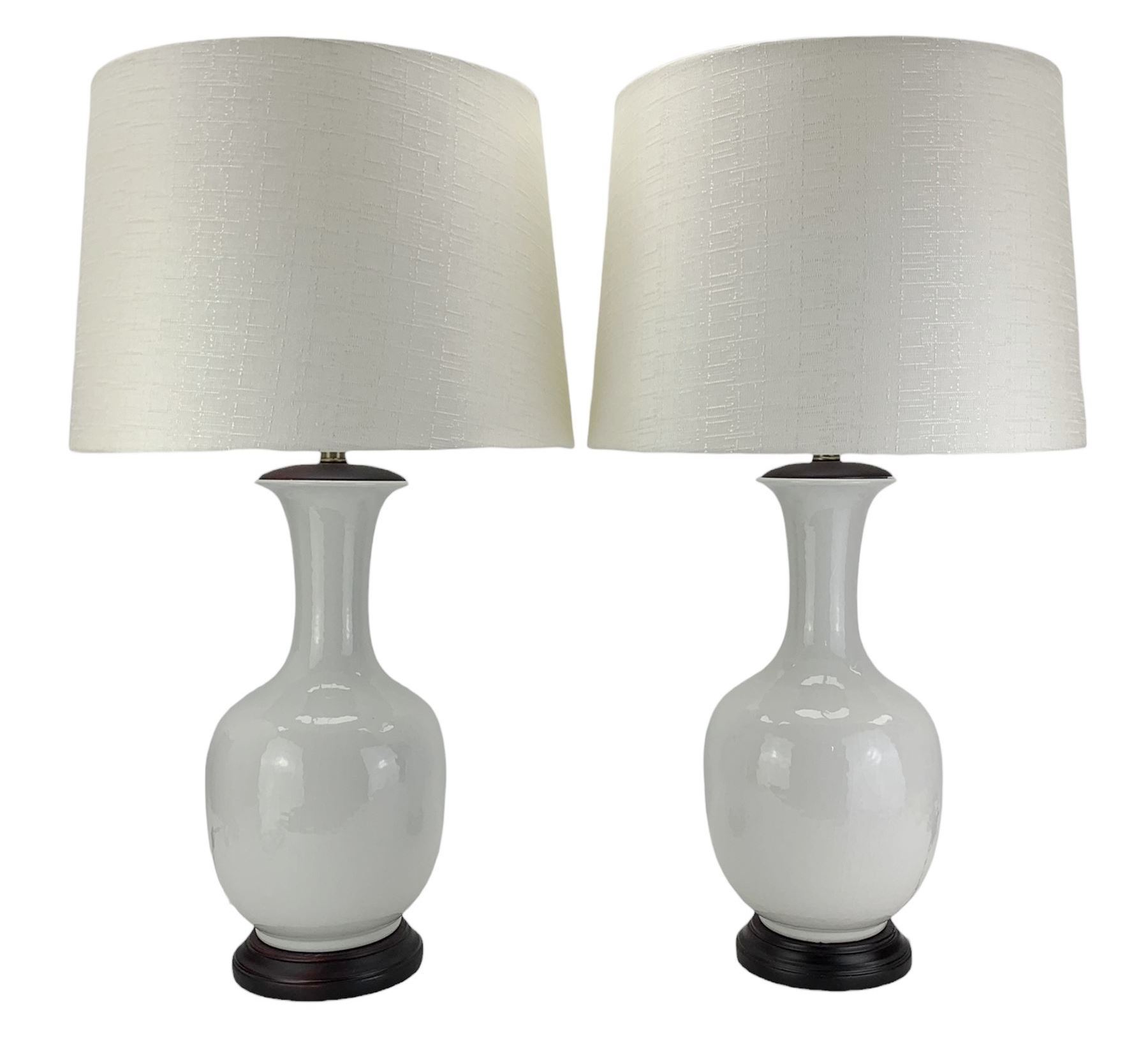 Pair of Chinese ivory crackle glazed table lamps, each of bottle form, raised upon circular hardwood bases, H43cm excluding fitting