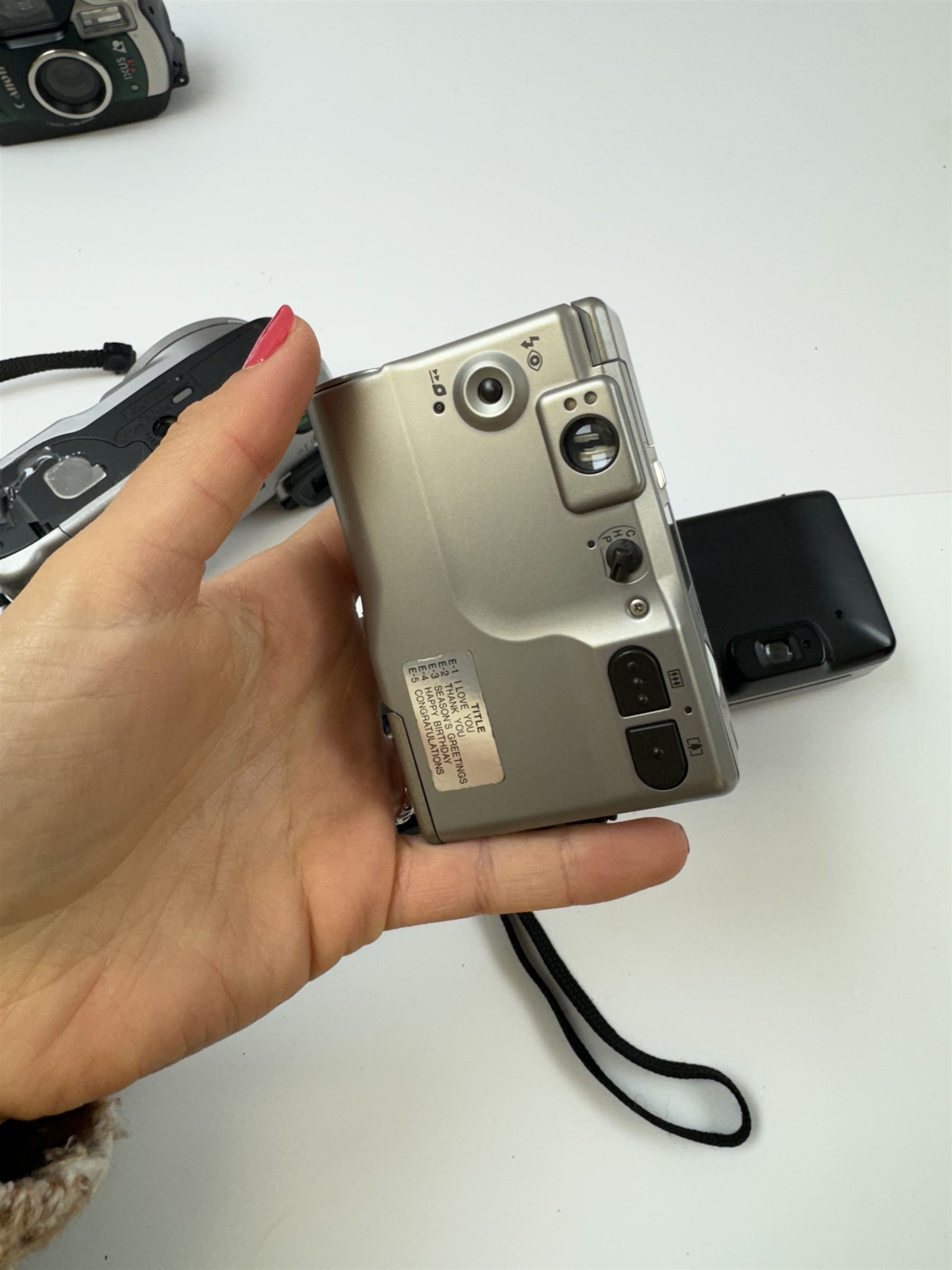 Eight Canon compact Ixus cameras, to include two Ixus examples serial nos. 2309147 & 2273184, Ixus M-1 serial no. 2932566, Ixus L-1 serial no. 2161988, Ixus Z90 serial no. 2201833,  Ixus X-1 serial no. 4704380, Z60IX serial no. 7474817, Ixus V2 serial no. 4431003237 and a Canon Powershot 350 digital camera serial no. H7MX00941