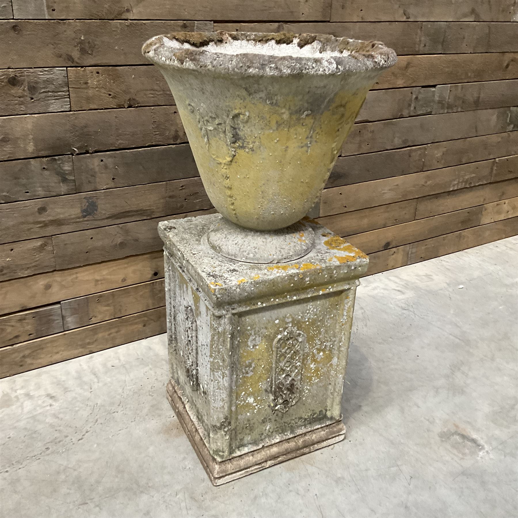 Cast stone vase shaped urn, mounted on square plinth