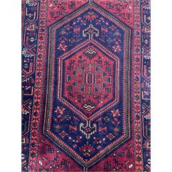Persian Hamadan red ground rug, the field decorated with geometric motifs, triple band border with repeating design