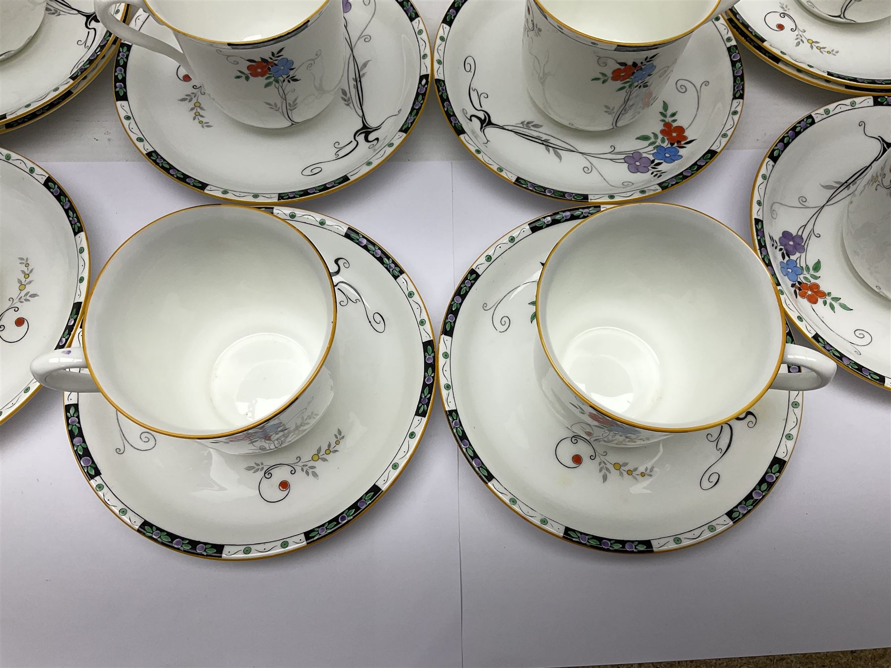 Art deco Shelley tea service for eight, decorated with floral sprigs, comprising teacup and saucers, dessert plates, two cake plates, milk jug and open sucrier, with to extra dessert plates