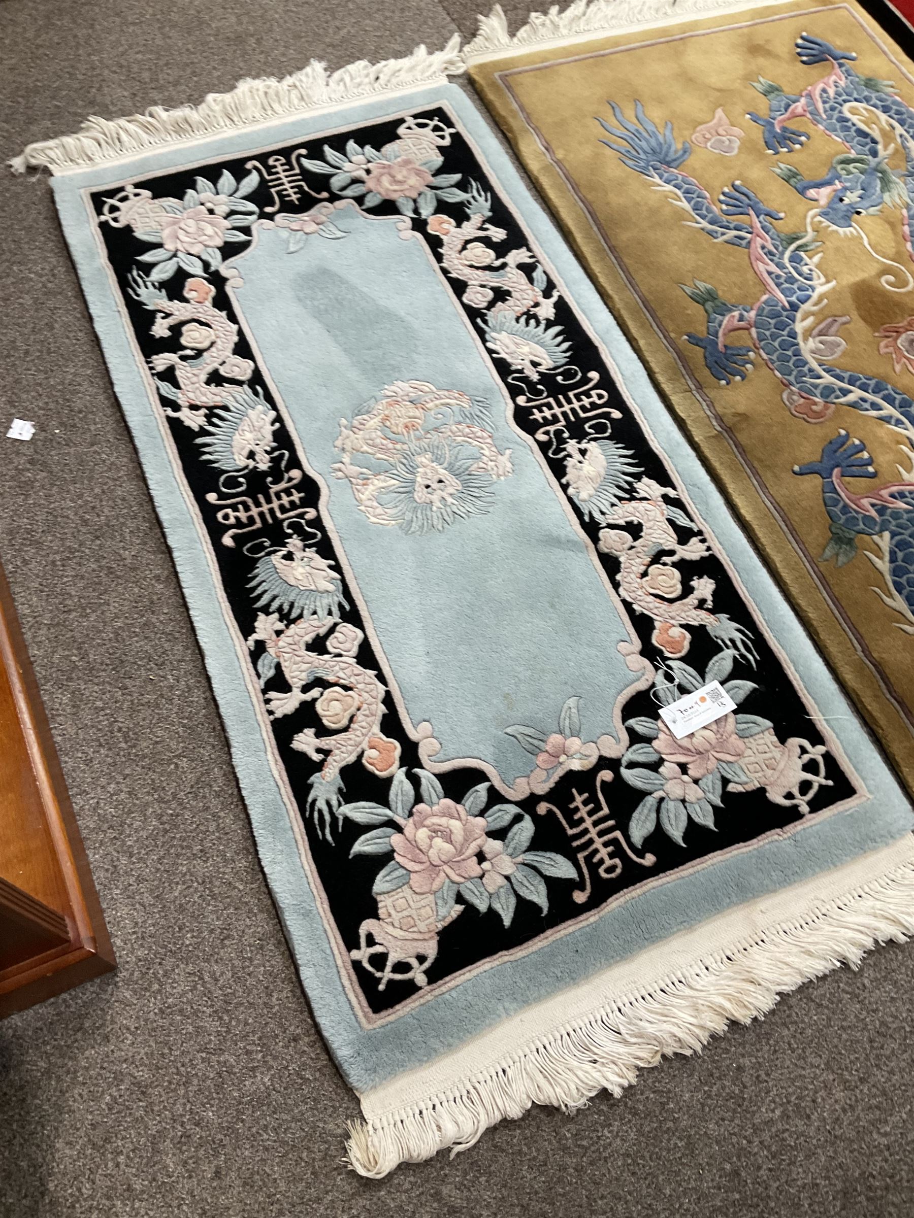 Collection of four Chinese washed woollen rugs - blue ground (153cm x 92cm); red and black ground (156cm x 94cm); light blue ground (138cm x 70cm); gold ground (153cm x 77cm)