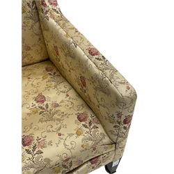 Edwardian hardwood-framed armchair, upholstered in floral pattern fabric, on square tapering front supports, brass and ceramic castors 