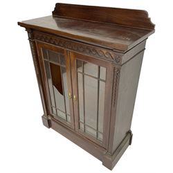 19th century mahogany display cabinet, rectangular top over frieze decorated with Vitruvian scroll mount, enclosed by two astragal glazed doors, the upright rails decorated with trailing bellflowers, on moulded plinth