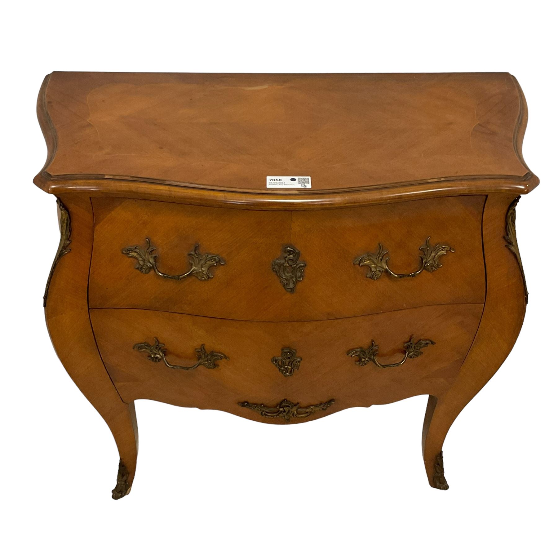 Late 20th century French design walnut bombe chest, shaped moulded top with quarter-matched veneers within crossbanding, fitted with two drawers with foliate cast metal handles and escutcheons, on tapering supports with ornate cast caps 