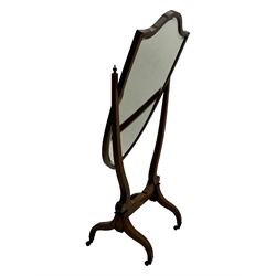 S. & H. Jewell - Edwardian mahogany cheval dressing mirror, shield shaped bevel edged mirror plate within an inlaid mahogany frame, supported by a pair of curved uprights topped with finials and terminating in a scroll design with floral inlay, the reverse bearing makers plaque, standing on four shaped supports fitted with brass castors