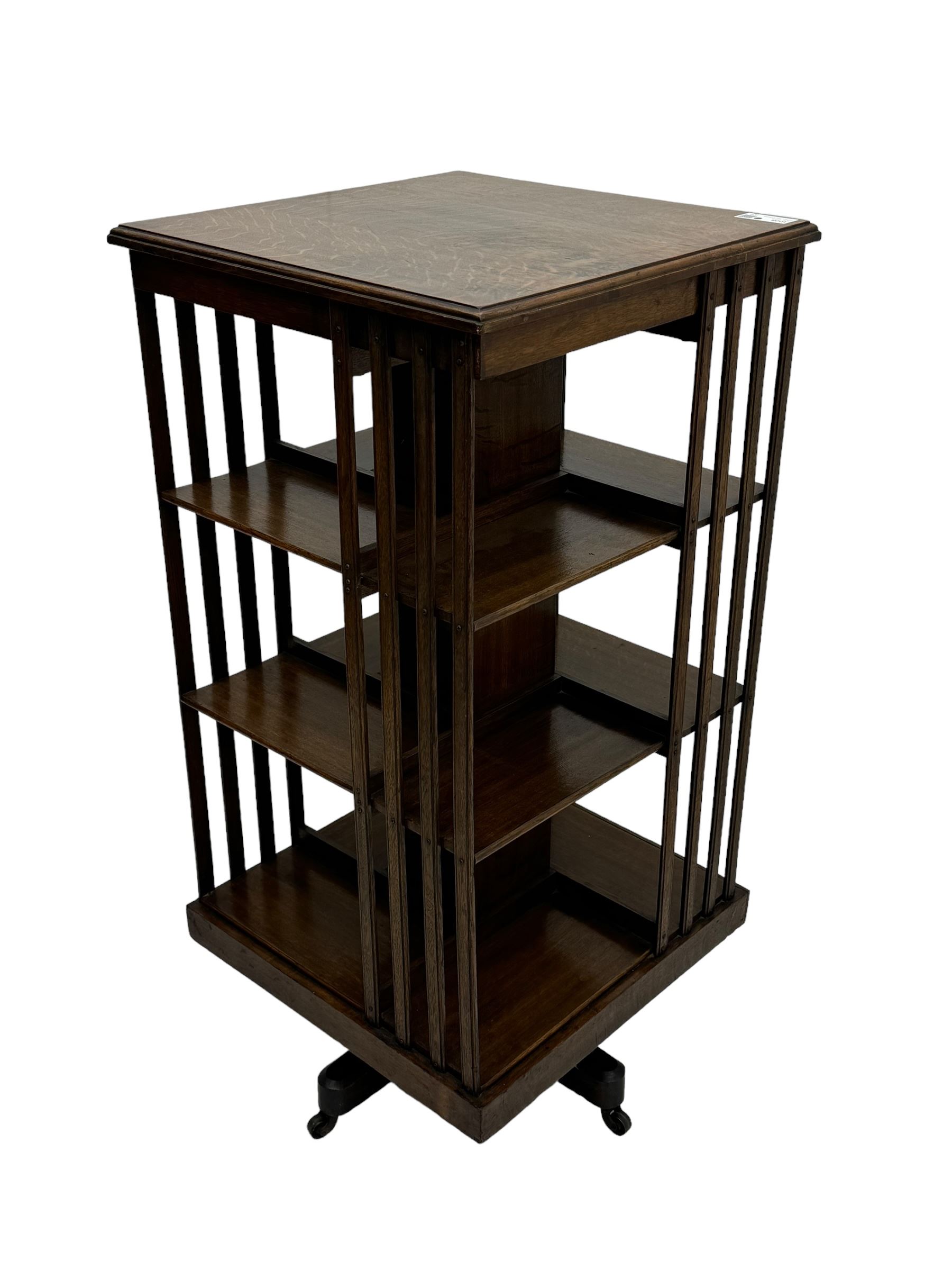 Early 20th century oak revolving bookcase, moulded square top over three tiers, with moulded vertical slats, on four spoke base with castors 