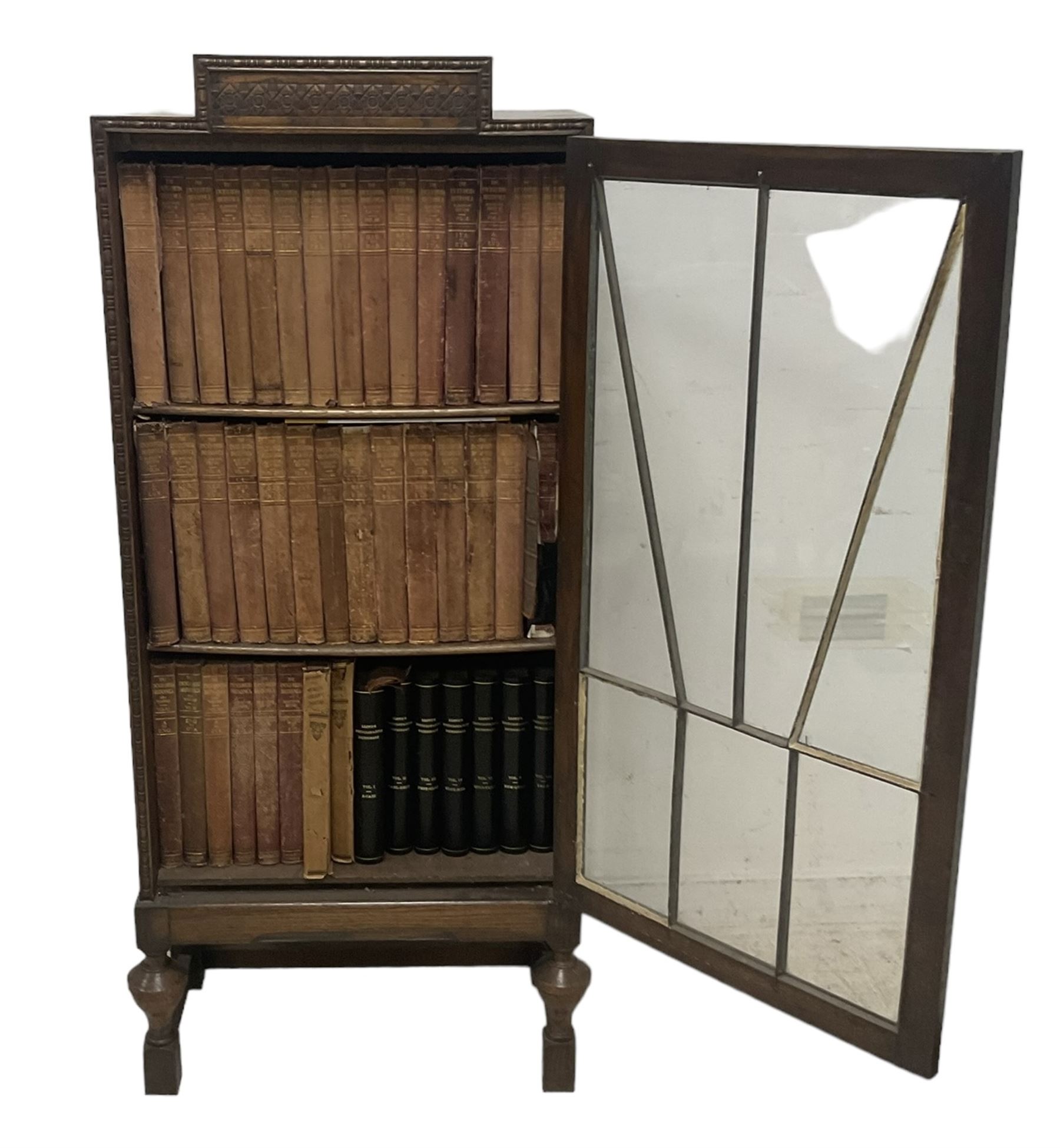 Edwardian oak bookcase, stepped top decorated with beading and stylised floral frieze, single astragal glazed door enclosing encyclopaedias and other books, on turned front feet united by plain stretchers 