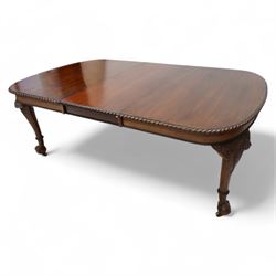 Early 20th century telescopic extending dining table, gardroon carved rectangular top with rounded ends, scrolled acanthus leaf carved cabriole supports with ball and claw feet, on brass castors, with two additional leaves  