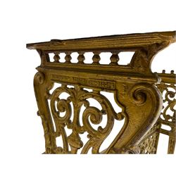 Pair of 19th century cast iron entrance tables, rectangular marble top over ornate gilt bases with scrolling foliate design and sledge feet, united by balustrade stretcher with scroll spandrels