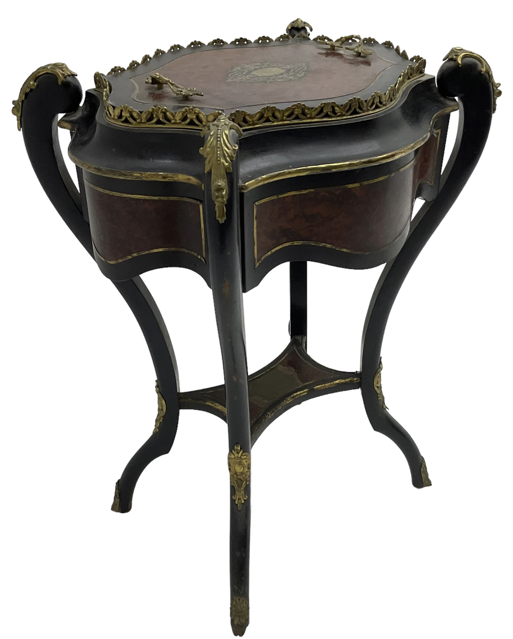 Late Victorian ebonised and amboyna wood jardinière planter, shaped form with removable lid inlaid with scrolling brass work and mounted by ornate cast gilt metal handles, the frieze rails inlaid with amboyna panels and brass stringing, on cabriole supports united by under-tier, decorated with cast gilt metal acanthus leaves and hooved feet caps