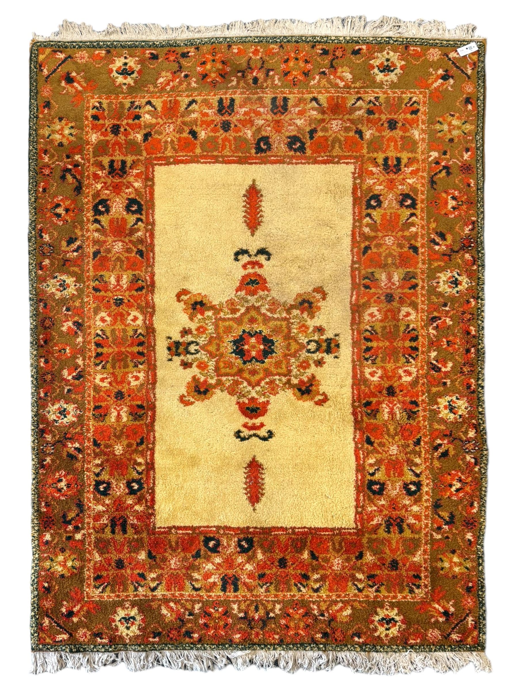 Moroccan amber ground thick pile rug, the plain ivory field decorated with a central pole medallion of star form, the wide guard bands decorated with repeating geometric and foliate patterns