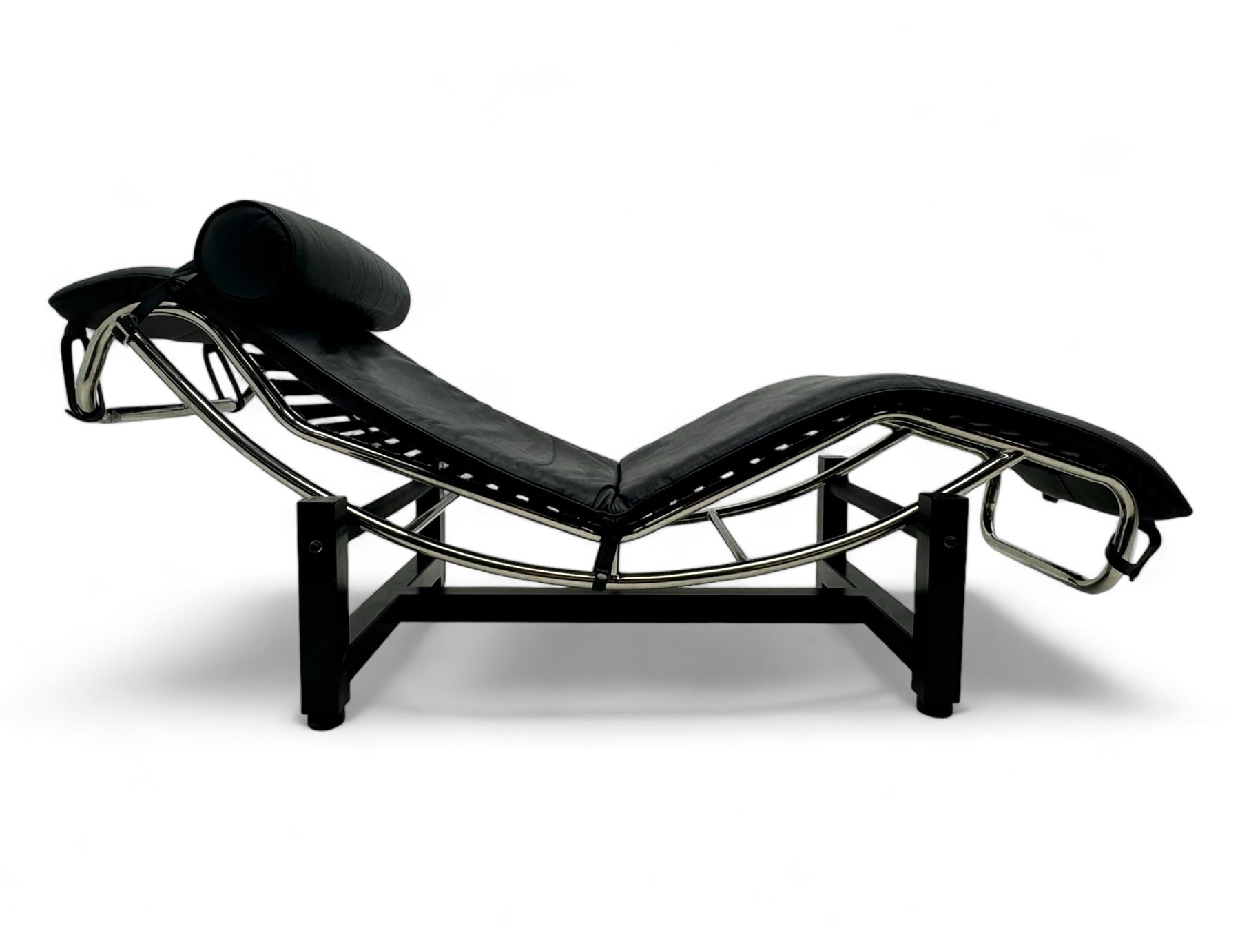 After Le Corbusier, Pierre Jeanneret, and Charlotte Perriand - LC4 chaise longue, black leather upholstery with cylindrical headrest, supported by a chromed tubular steel frame, with cantilever design with elastic webbing