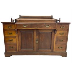 Victorian walnut clerk's desk, raised central section with tambour roll over hinged top, the interior fitted with leather inset writing surfaces, small drawers, document divisions and pen and ink stand, central drawer over double panelled cupboard, flanked by two banks of four graduating drawers, on bracket feet 