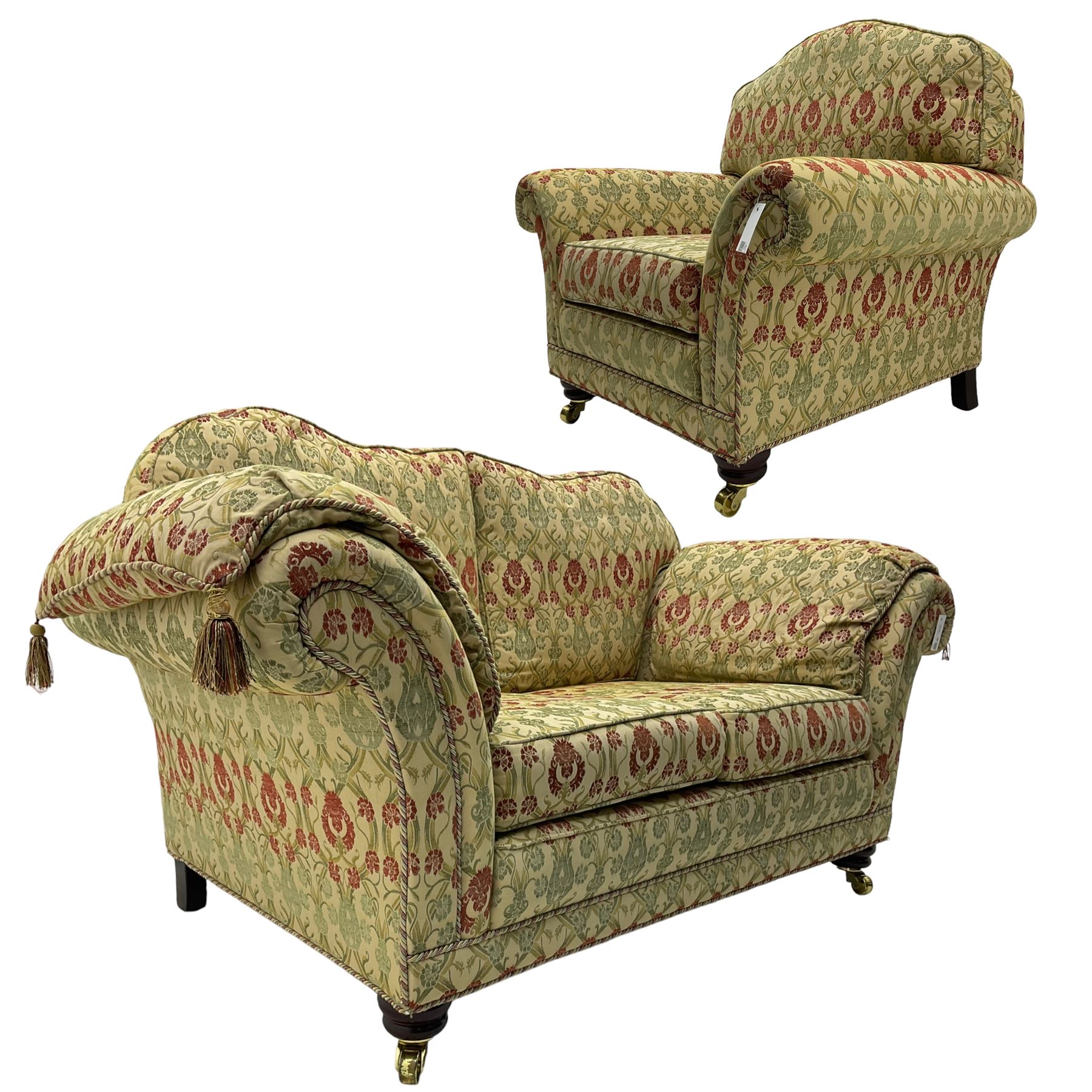 Traditional design two seat sofa, high back with scrolled arms, upholstered in beige fabric with red and green damask motifs, on castor supports (L178cm, D100cm, H89cm); matching armchair (L109cm, D89cm, H89cm)