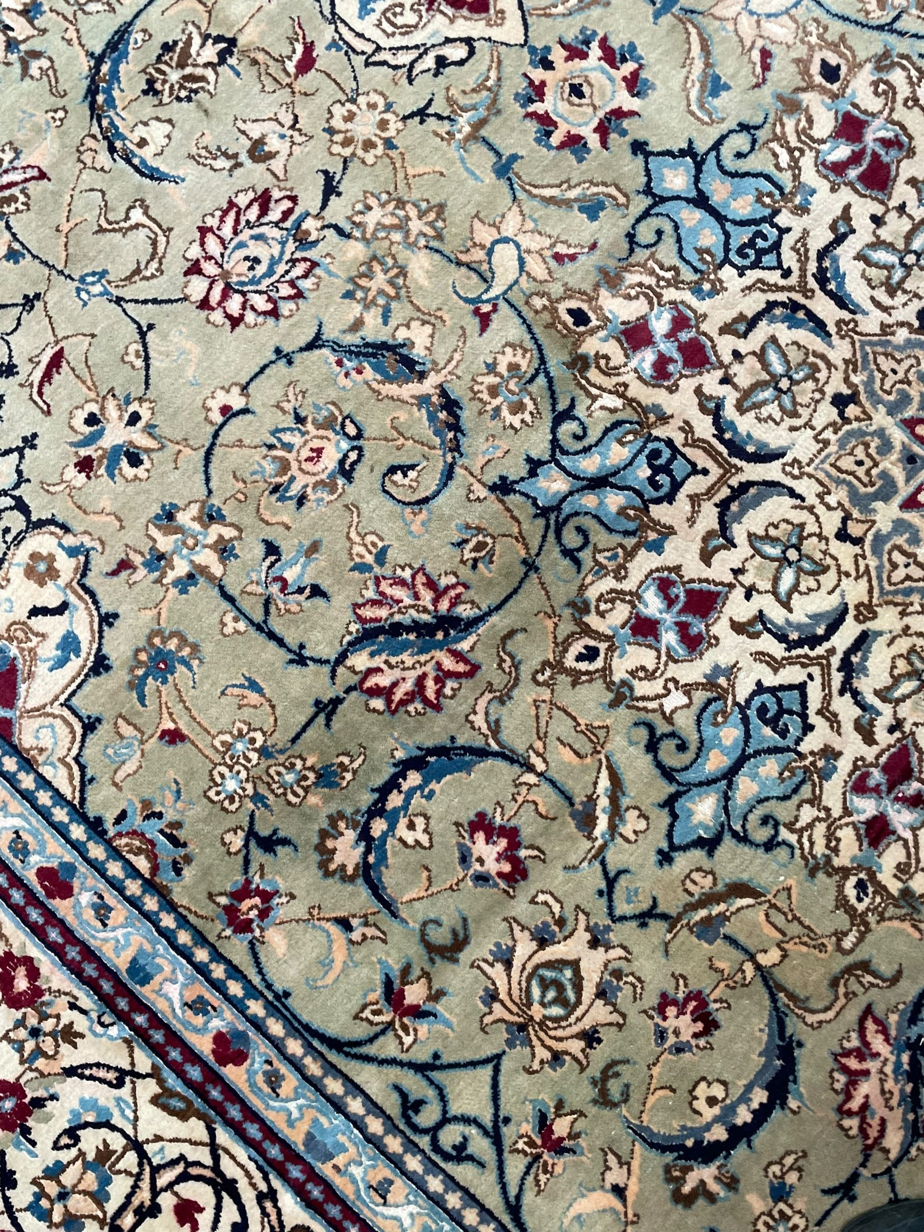 Persian Kashan olive ground carpet, central rosette medallion surrounded by swirling leafy branches and palmettes, the spandrels decorated with further palmettes and foliate motifs, scrolling border interspersed with stylised plant motifs, with in guard stripes