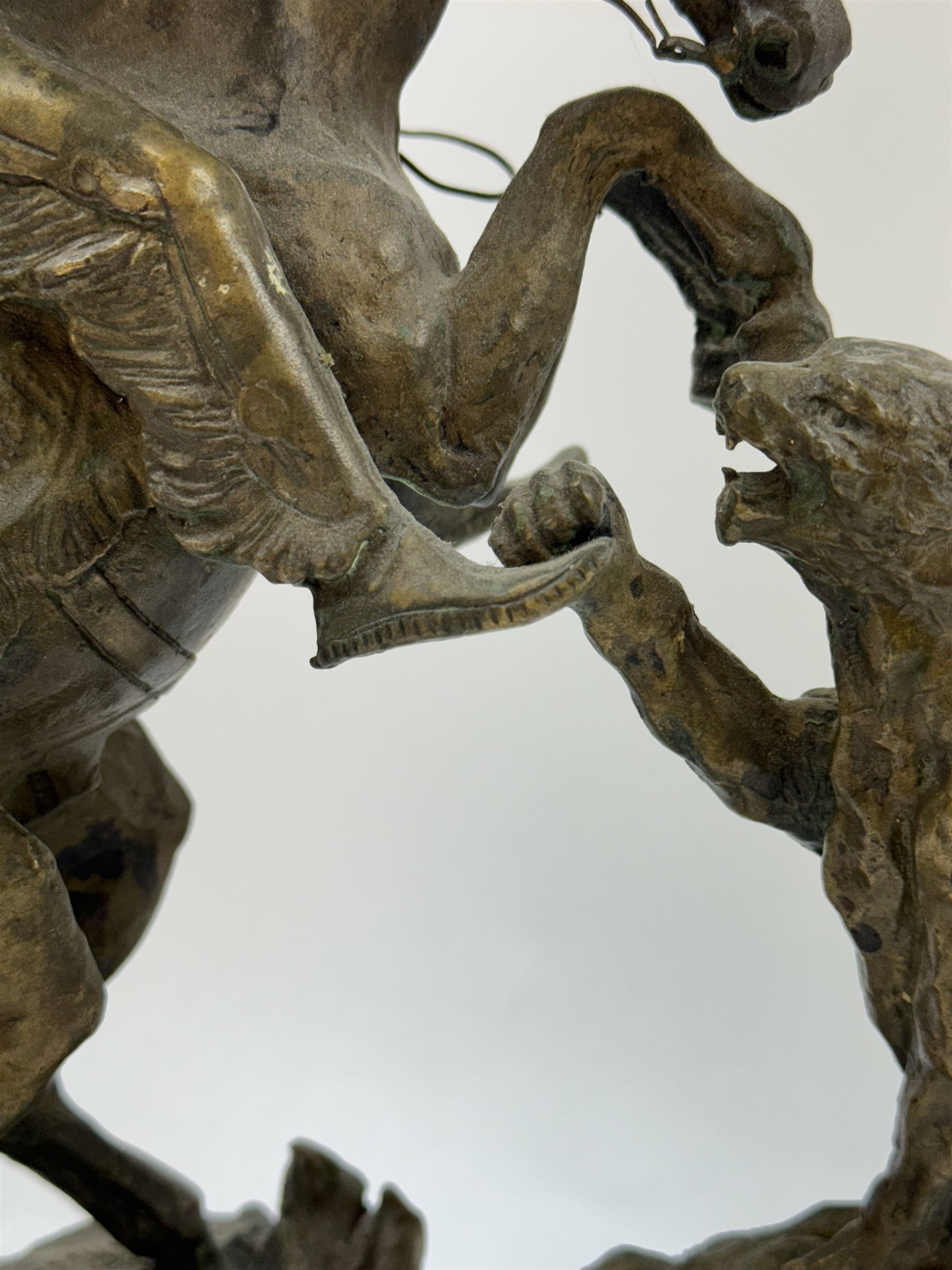 After Charles Marion Russell; Bronzed sculpture depicting man on horseback fighting a mountain lion, H42cm