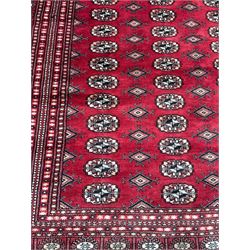 Persian Bokhara red ground carpet, decorated with six rows of traditional Gul motifs, multiple band border decorated with geometric patterns and motifs 